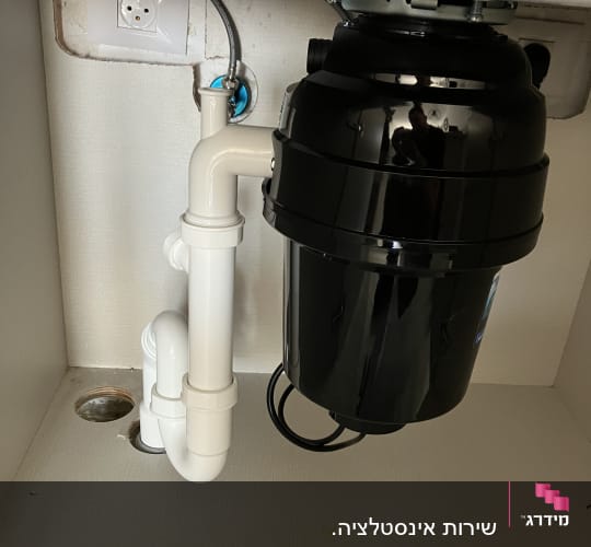 מתקן טוחן אשפה מתחת לכיור במטבח